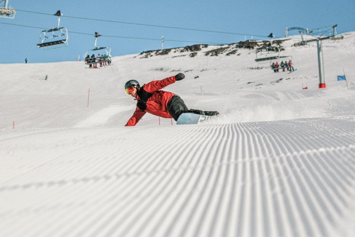 Skiiers look out at the snowy Remarkables