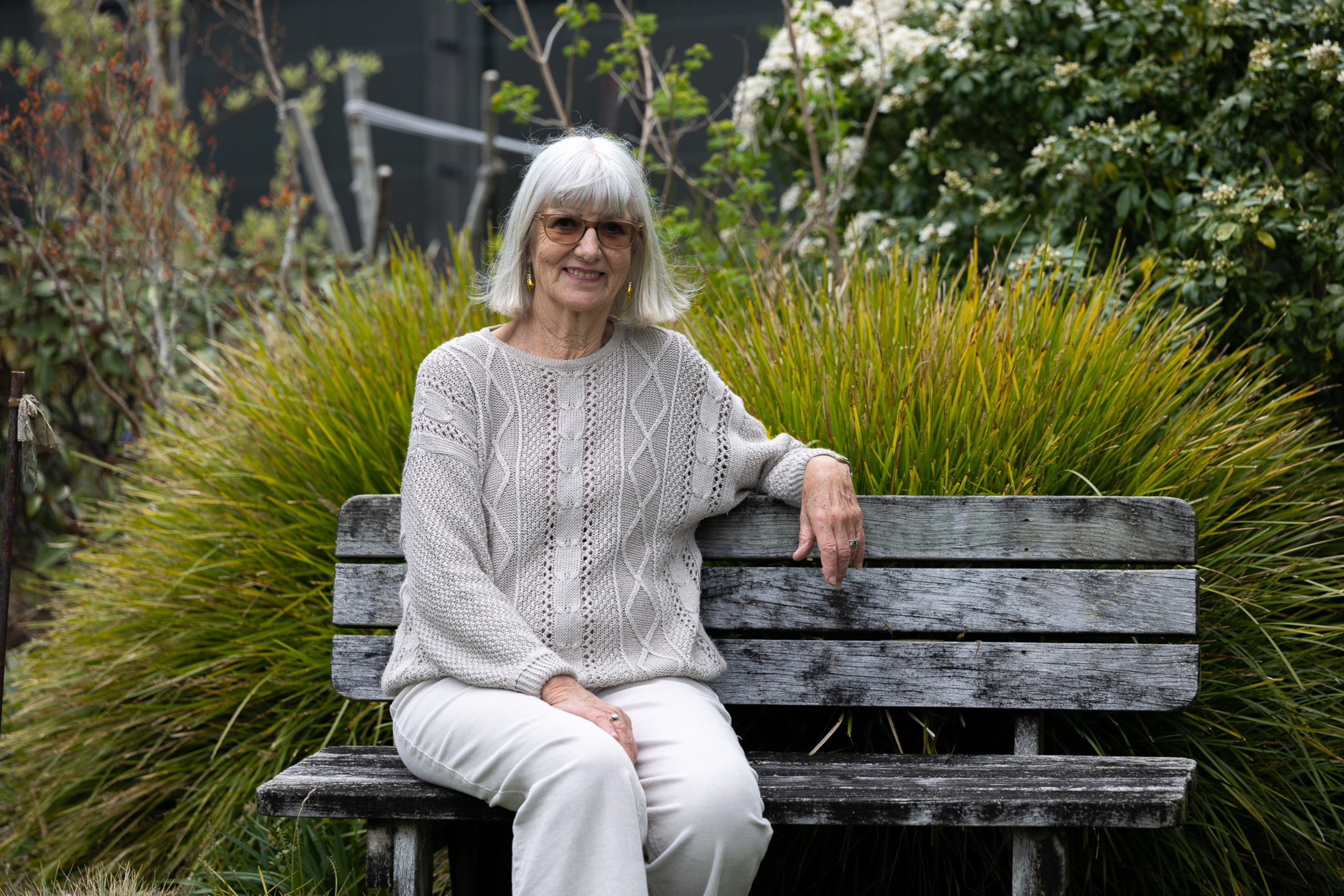 Gabrielle Sorensen sits on a bench in her garden.