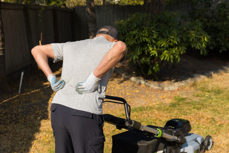 Man with sore back whilst mowing lawn.