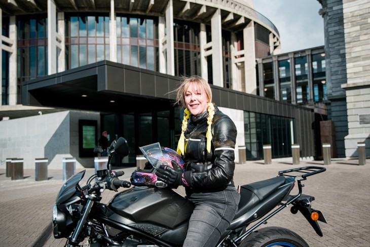 Natasha poses on her bike in front of the Beehive