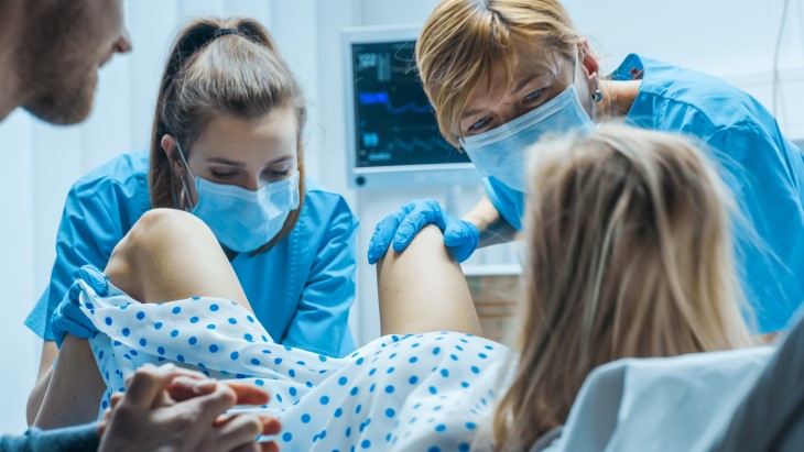 Nurses help a woman give birth