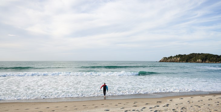 Michael walks into the sea in foamy breakers