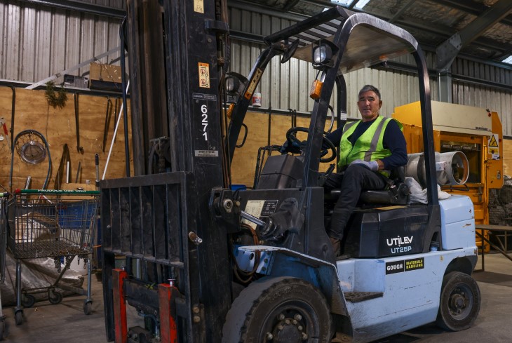 Michael sits on his forklift