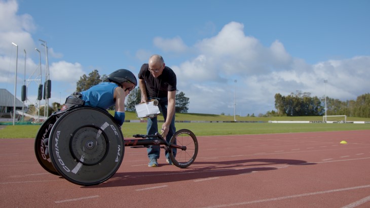 Para athlete and his coach on the track.