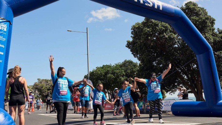 A team crosses the finish line at Round the Bays Auckland