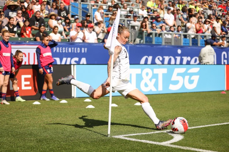 Ria Percival dribbling a football on the pitch.