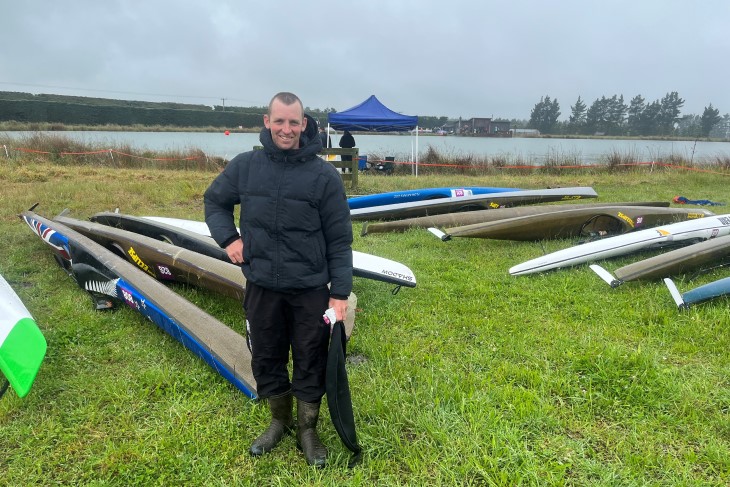 Stu smiles for a photo by his kayak