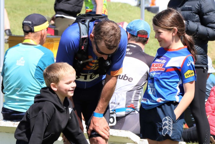 Stu bends over exhausted, with his young son and daughter in front of him