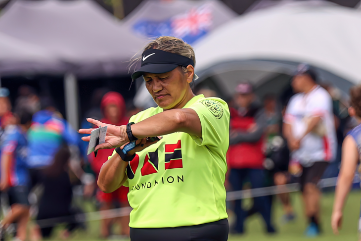 Tina in her high-vis referee gear, looks at her watch.