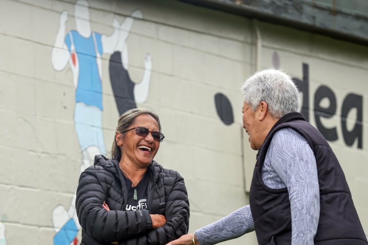 Tina laughing with an older person