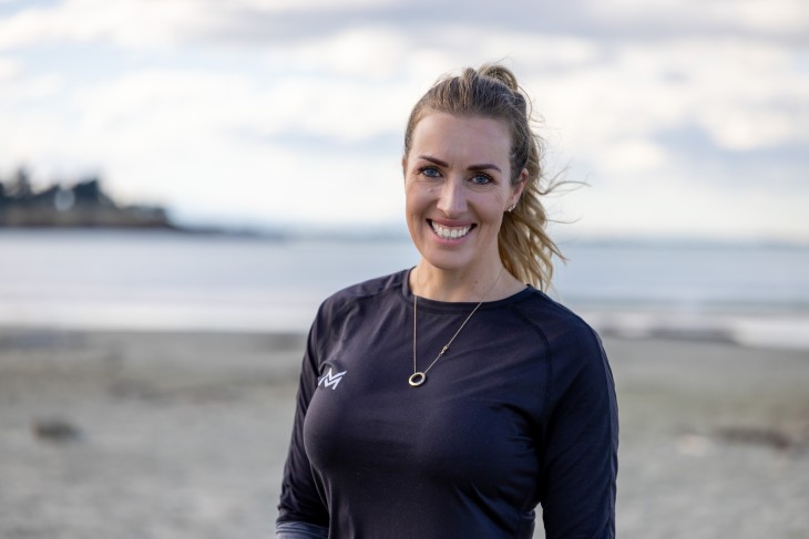 Alicia Mabey standing on the beach and smiling.