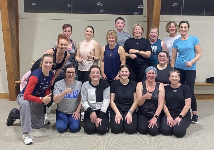 A group photo showing Alicia Mabey with members of her fitness classes, she's wearing a moonboot.