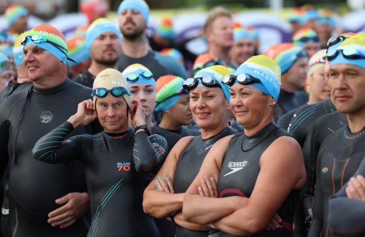 Amanda Hita standing with lots of other competitors in their wetsuits waiting for the swim leg of IronMāori to start.