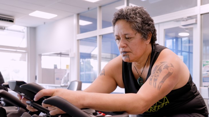 Aroha Te Wao working out on an exercise bike. 