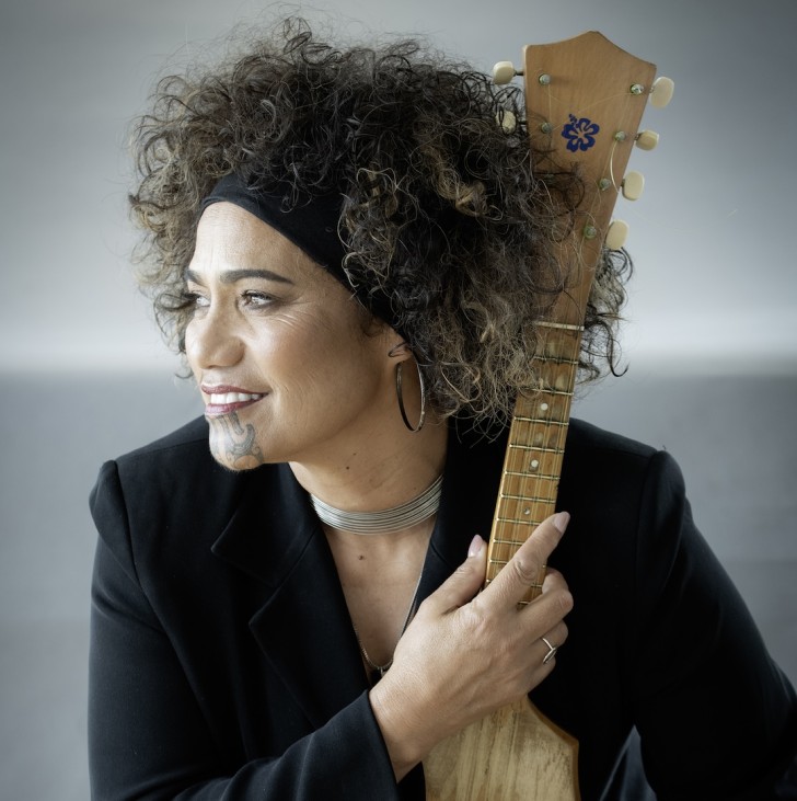 A side profile photo of Betty-Anne Hall holding her ukelele.