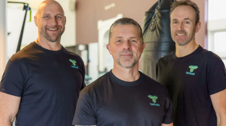 Brendon Timmins posing for a photo with two male colleagues from Otago Polytechnic.