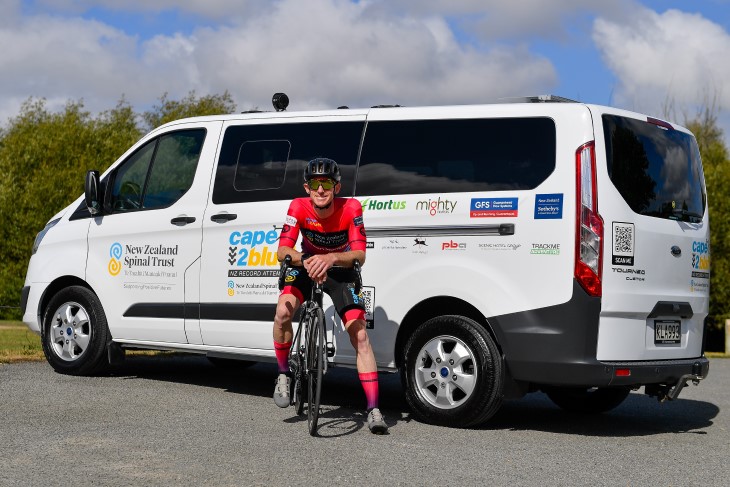 Brendon Vercoe sitting on his bike in front of a van. 