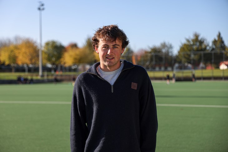 A portrait photo of Campbell Gray standing on a hockey field. 