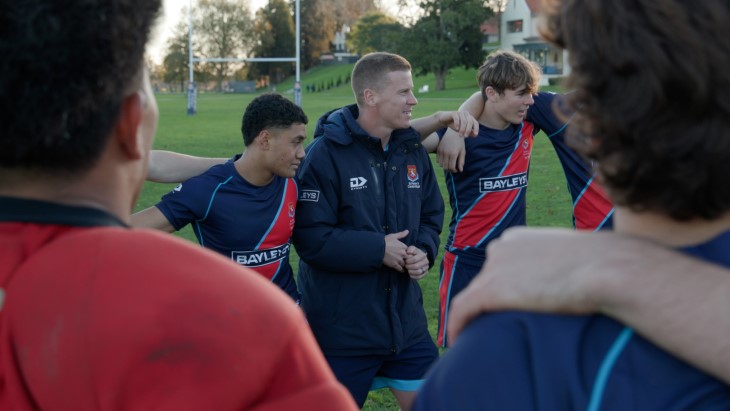 Carl Perry in a huddle with his players at rugby training. 