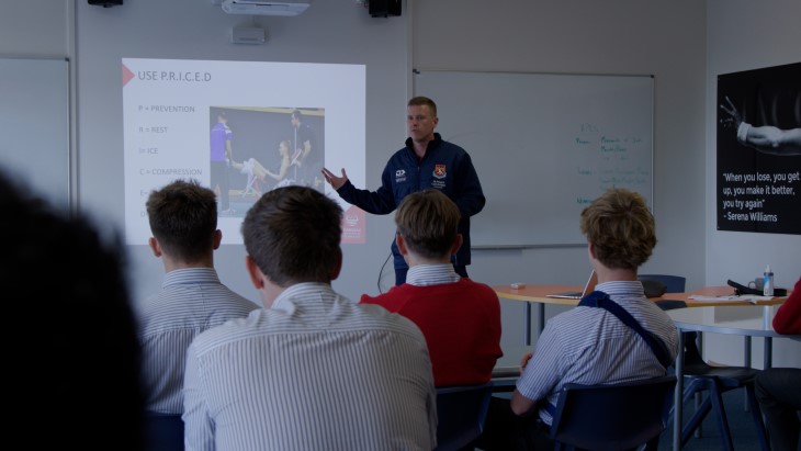 Carl Perry at the front of his class teaching a PE theory session.