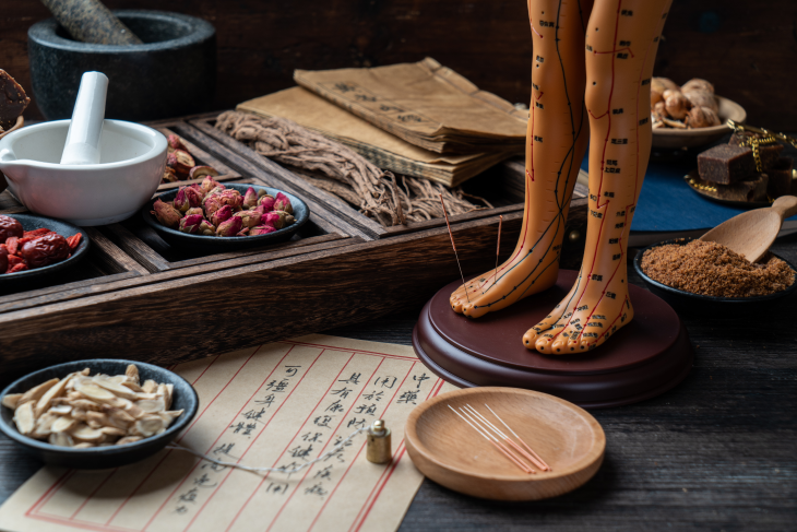 A table displaying some of the herbal remedies and acunpuncture utensils used in Chinese medicine.