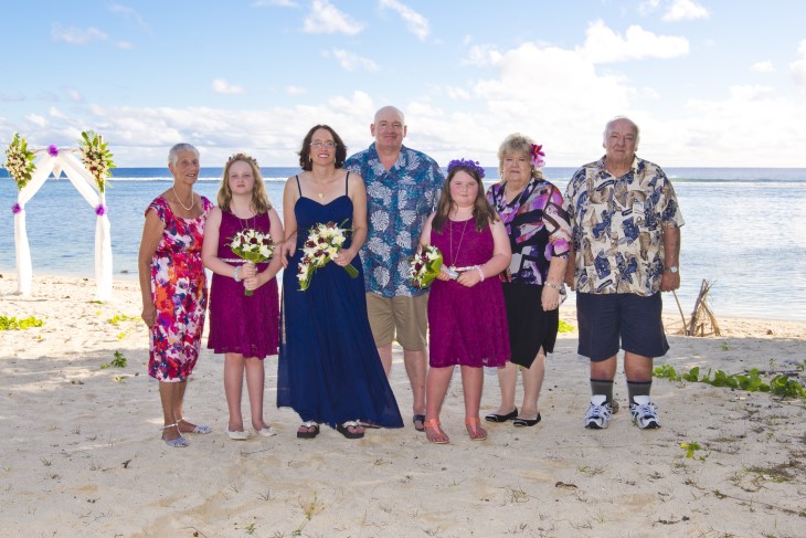 Darren Guard standing with his family on a beach. 