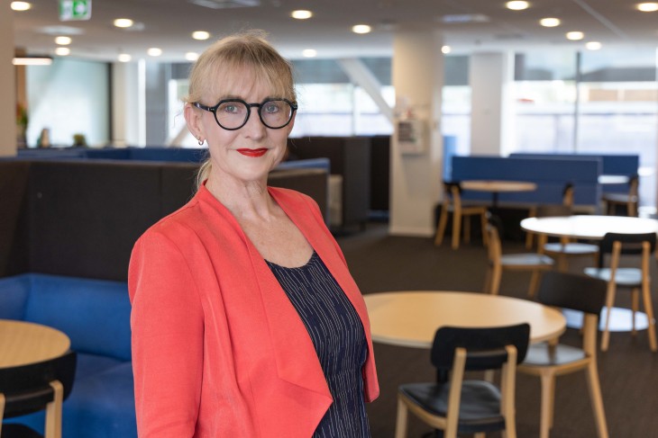 Dr Jo Prendergast standing in open plan office.