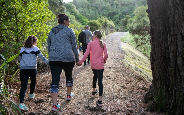 Family walks on a trail holding hands