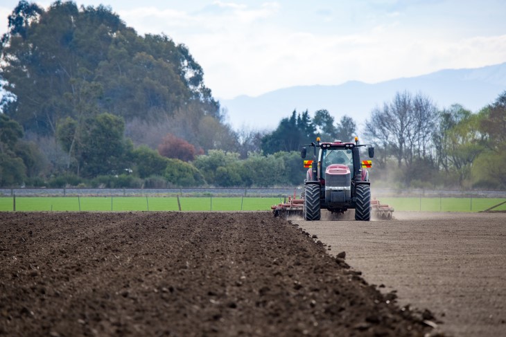 A farmer ploughing a field in his tractor. 