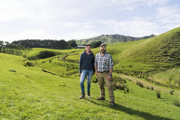 Farmers Emma Crutchley and Jon Pemberton standing in a field and smiling.