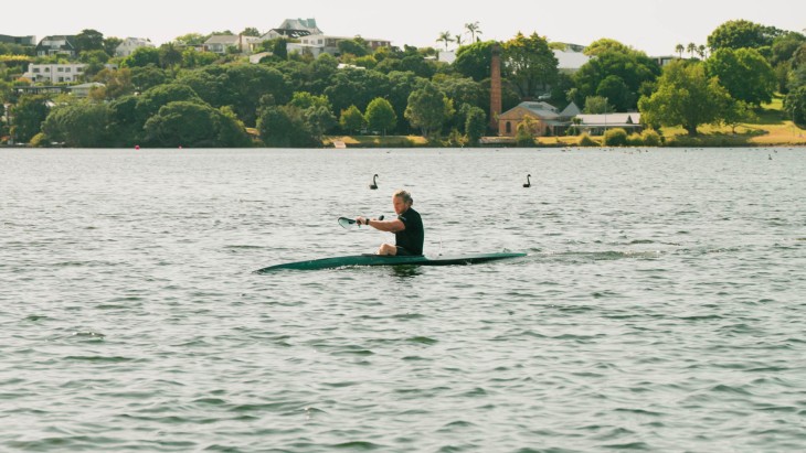Finn Murphy rowing in his canoe on a lake.