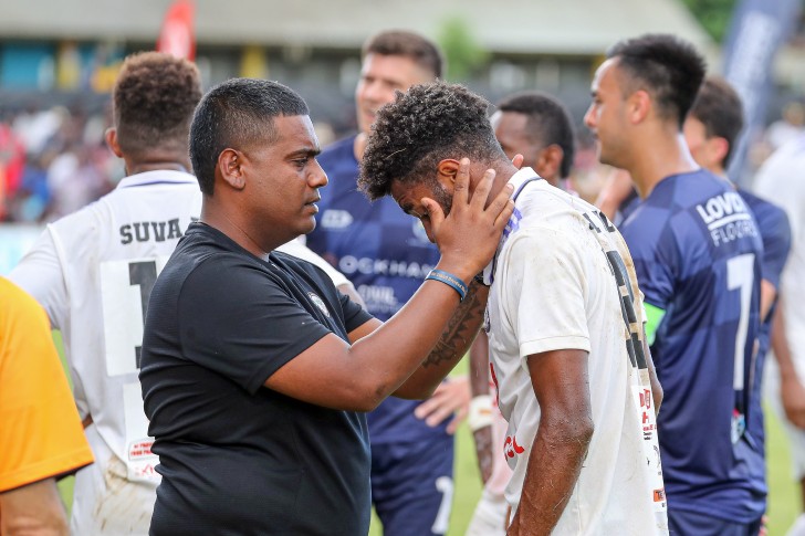 A physio checking a football player for concussion on the field. 