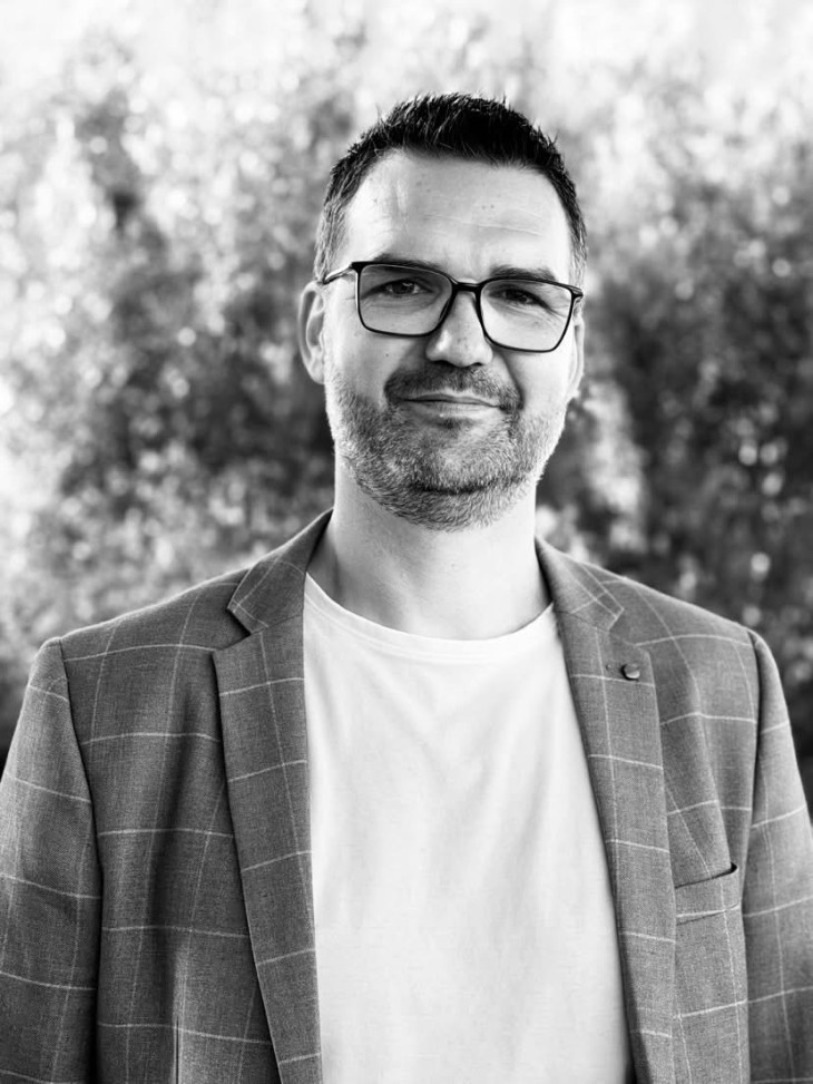 A black and white portrait photo of Grant Sweeney.