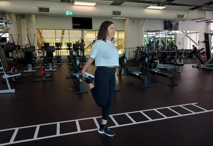 Hala stretching her leg in the gym.