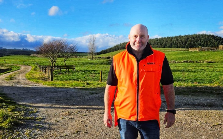 Jason Halford standing on his farm and smiling.