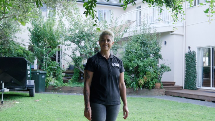 Jolie Davis standing in the backyard of her house and smiling. 