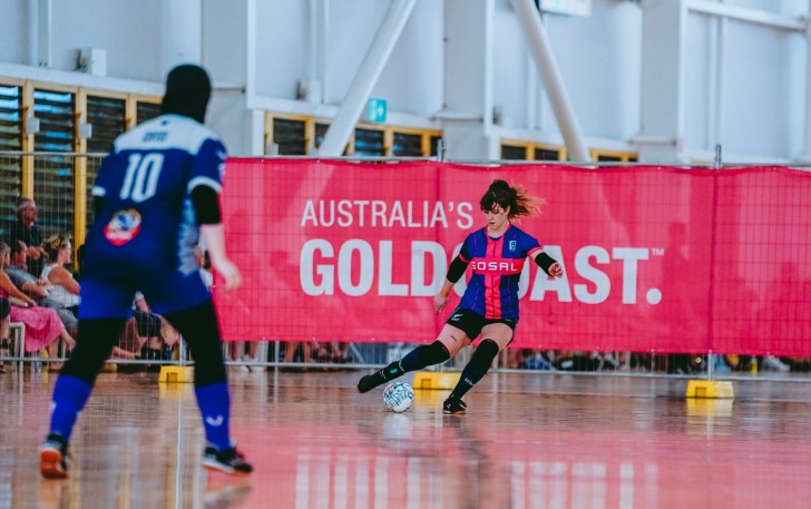 MacKenzie Falco passing the ball on a futsal court.