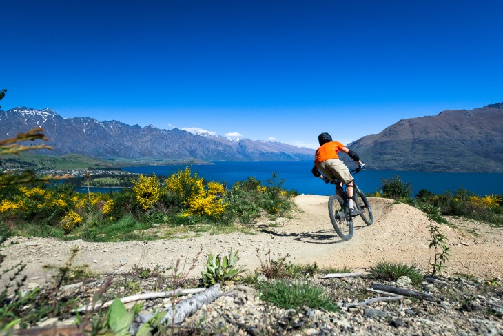 A mountain biker riding down a hill in beautiful scenery 