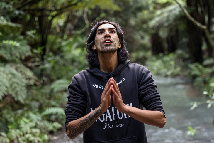 Nikau Munroe-Rawiri stands in the water of a river. 