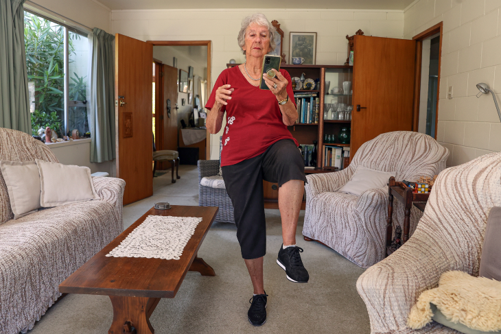 An older woman using the Nymbl app to do balance exercises.