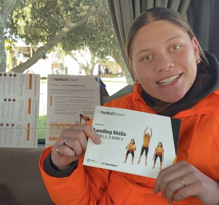 Paris Lokotui holds up a NetballSmart handbook. 