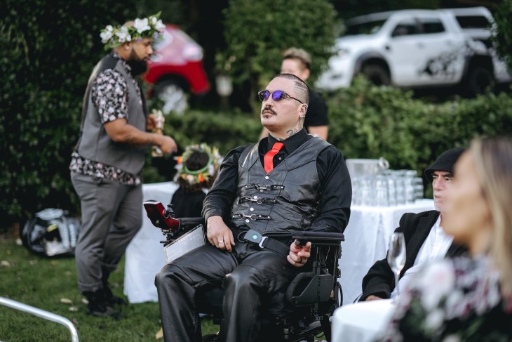Raymond Ruru sitting in his wheelchair at a wedding. 