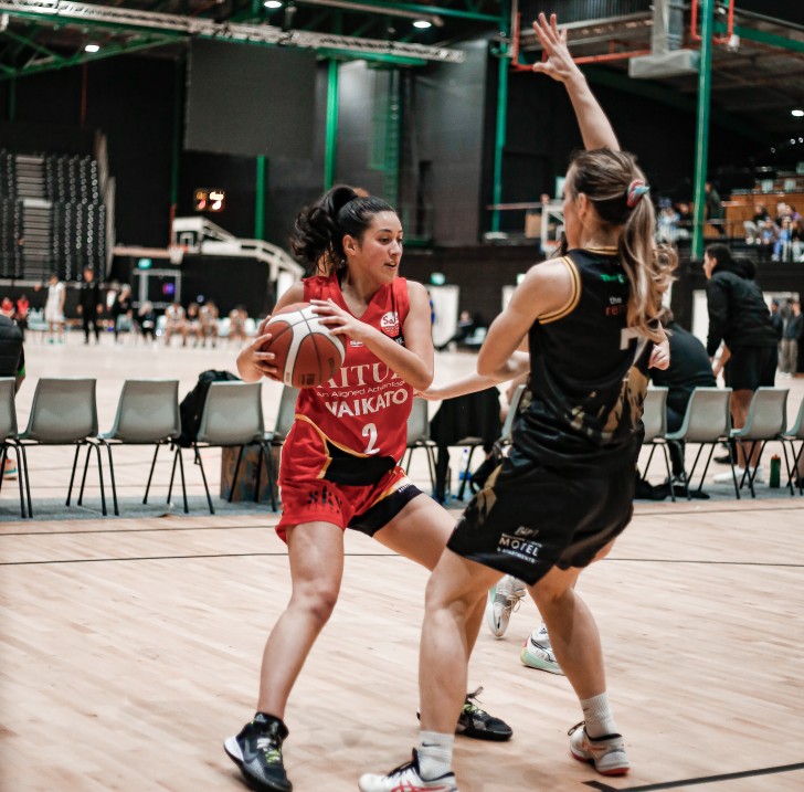 Riva Pitman holding the ball in her hands and trying to get past an opponent.