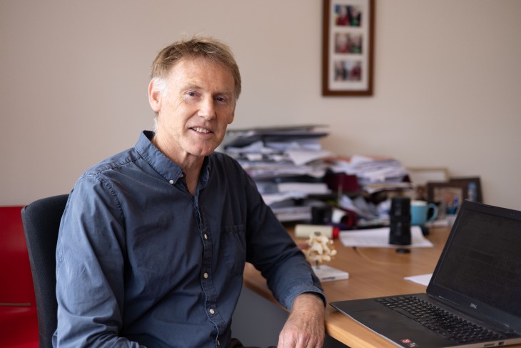 Dr Rod Nicholson sitting at the desk in his clinic.