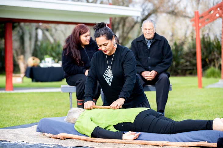 A rongoā Māori practitioner using her healing methods on a woman.
