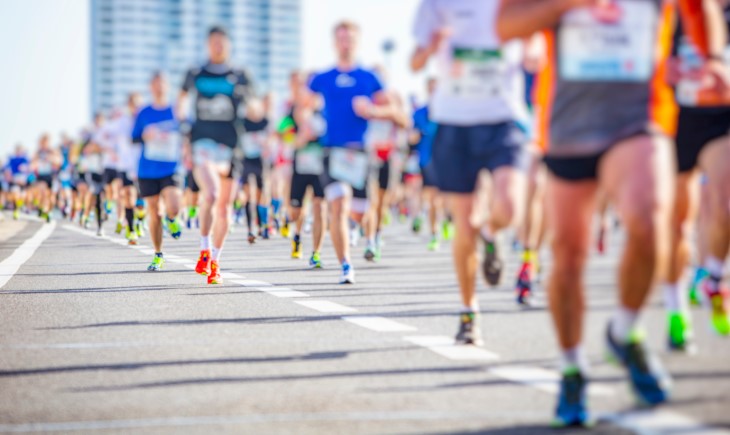 A large group of people running towards the camera during a running event.