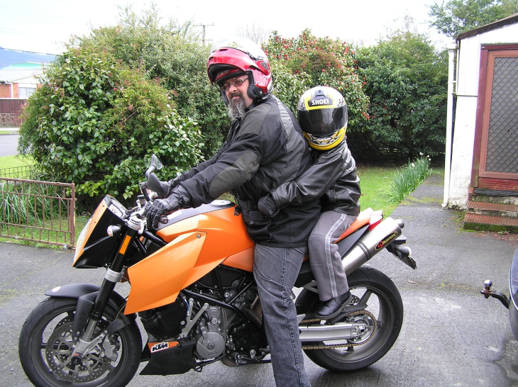 Simon Gotlieb sitting on his motorbike with a young boy. 