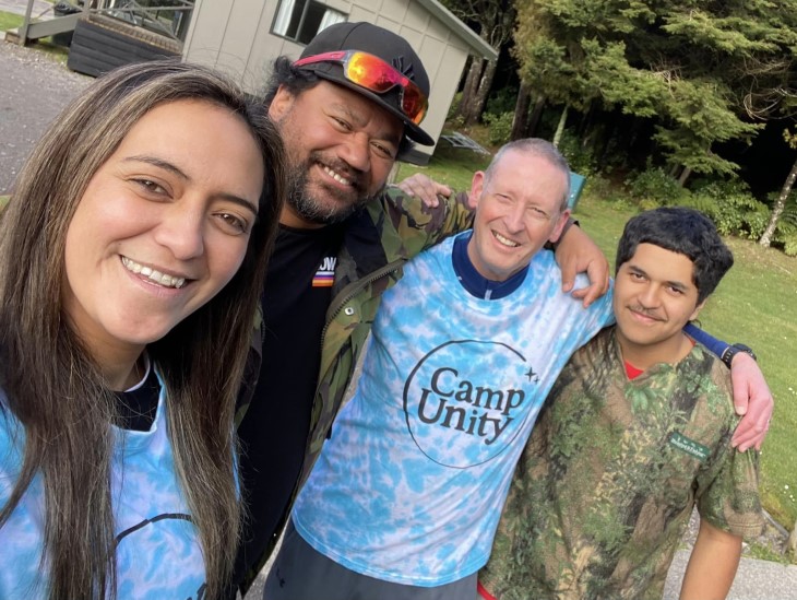 Te Rina standing with members of Camp Unity, who are all smiling at the camera. 