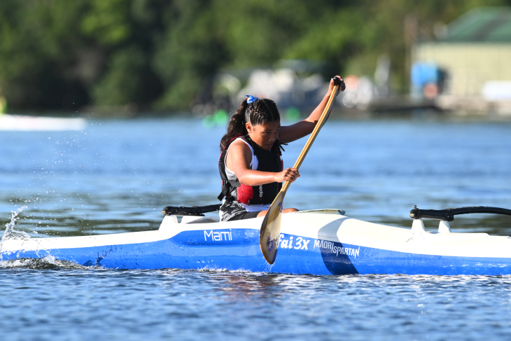 A young woman paddling in her outrigger canoe during a waka ama event. 