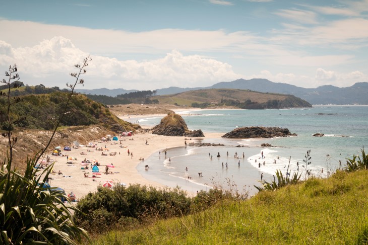 A long-distance shot of a busy beach on a sunny day. 